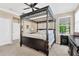The main bedroom features a four-poster bed, neutral walls, and a window that allows for natural light at 15635 Starling Water, Lithia, FL 33547