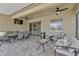 Covered patio with an outdoor dining set, comfortable seating, ceiling fans, and a view of the outdoor scenery at 15635 Starling Water, Lithia, FL 33547