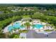 Aerial view of a community pool with palm trees, a splash pad, and lounge areas for relaxation and recreation at 15635 Starling Water, Lithia, FL 33547