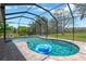 Screened pool features a blue inflatable and beautiful lush green surroundings on a sunny day at 15635 Starling Water, Lithia, FL 33547
