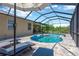 Screened-in pool area featuring a pool with chairs, an umbrella, and a sunny patio in a backyard setting at 15635 Starling Water, Lithia, FL 33547