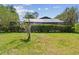 Backyard featuring mature landscaping and screened enclosure offering a private outdoor oasis at 16503 W Course Dr, Tampa, FL 33624