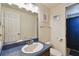 Well-lit bathroom features a vanity with blue countertops and a shower with a blue curtain at 16503 W Course Dr, Tampa, FL 33624