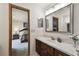 Bright bathroom features vanity with a marble countertop, mirror, vanity lighting, and a view into the bedroom at 16503 W Course Dr, Tampa, FL 33624