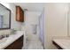 Simple bathroom with vanity, mirror, tiled floor, built in shelves, and shower with curtain at 16503 W Course Dr, Tampa, FL 33624