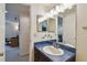 Bathroom vanity with mirror offers ample lighting and adjoins a hallway with office at 16503 W Course Dr, Tampa, FL 33624