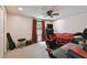 Bright bedroom with ample sunlight, ceiling fan, gaming chair, and adjacent workstation at 16503 W Course Dr, Tampa, FL 33624