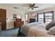 Comfortable bedroom with a sliding glass door to a balcony, dresser, tv and ceiling fan at 16503 W Course Dr, Tampa, FL 33624