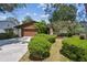 Charming home featuring a brown exterior, well-kept landscaping, and a two-car garage at 16503 W Course Dr, Tampa, FL 33624