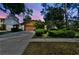 Charming home featuring a brown exterior, well-kept landscaping, and a two-car garage at twilight at 16503 W Course Dr, Tampa, FL 33624