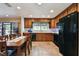 Kitchen with dark appliances, wooden cabinetry, and a table with seating for four at 16503 W Course Dr, Tampa, FL 33624
