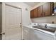 Bright laundry room with washer, dryer, and overhead cabinets for ample storage at 16503 W Course Dr, Tampa, FL 33624