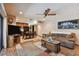 Open-concept living room with wood floors, a ceiling fan, and a decorative area rug near the kitchen/dining area at 16503 W Course Dr, Tampa, FL 33624