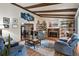 Open living room with exposed beam ceiling, fireplace, and hardwood flooring at 16503 W Course Dr, Tampa, FL 33624