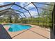 Inviting screened pool surrounded by lush landscaping and a sunny patio at 16503 W Course Dr, Tampa, FL 33624