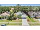 An elevated view of a well-maintained home featuring solar panels, a spacious yard, and an attached two-car garage at 18013 Palm Breeze Dr, Tampa, FL 33647