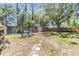 A well-maintained fenced backyard featuring mature trees, a fire pit, and cozy seating, perfect for outdoor enjoyment at 18013 Palm Breeze Dr, Tampa, FL 33647
