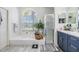 Modern primary bath features a standalone shower, garden tub under a large window and double vanity at 18013 Palm Breeze Dr, Tampa, FL 33647