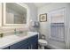 Bathroom features a vanity with an illuminated mirror, toilet, and window at 18013 Palm Breeze Dr, Tampa, FL 33647