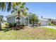 Charming single-story home with lush landscaping, manicured lawn, mature palm trees, and an attached two-car garage at 18013 Palm Breeze Dr, Tampa, FL 33647