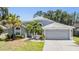 Attractive one-story home with a grey exterior, arched windows, a two-car garage and beautiful landscaping at 18013 Palm Breeze Dr, Tampa, FL 33647