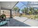 A covered lanai overlooking a well maintained fenced yard, with ample patio space and beautiful green views at 18013 Palm Breeze Dr, Tampa, FL 33647