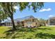 A charming backyard featuring a screen enclosed lanai, a well-maintained lawn, and a beautiful mature shade tree at 19129 Lake Audubon Dr, Tampa, FL 33647