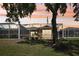Large screened-in back porch and backyard with mature shade tree and lush green grass at 19129 Lake Audubon Dr, Tampa, FL 33647