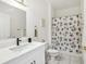 Modern bathroom features a white vanity, tile floors, and walk-in shower with a decorative shower curtain at 19129 Lake Audubon Dr, Tampa, FL 33647