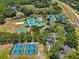 An aerial shot captures the community's amenities including tennis courts, and a resort-style pool at 19129 Lake Audubon Dr, Tampa, FL 33647