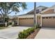 Home's two-car garage with decorative windows, landscaping, and driveway leading to street at 19129 Lake Audubon Dr, Tampa, FL 33647