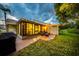 Backyard patio at dusk with furniture, decorative lights and view of lush greenery at 20 Windrush Bay Dr # 20, Tarpon Springs, FL 34689