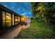 Backyard patio with decorative lights, grassy yard, and view of lush greenery at 20 Windrush Bay Dr # 20, Tarpon Springs, FL 34689