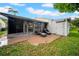 Backyard patio with outdoor seating and a screened-in porch, surrounded by lush greenery at 20 Windrush Bay Dr # 20, Tarpon Springs, FL 34689