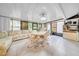 Bright sun room with tiled floors, floor-to-ceiling windows and a full-sized sofa at 20 Windrush Bay Dr # 20, Tarpon Springs, FL 34689