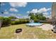 Backyard features an above ground pool with a small deck, a fire pit and tropical plants under a sunny sky at 2153 Catalina N Dr, Clearwater, FL 33763