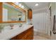 Neutral bathroom with a wood-trimmed vanity, mirror, and tiled floors at 2153 Catalina N Dr, Clearwater, FL 33763