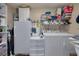 Functional laundry room with washer, dryer, refrigerator, and storage shelves at 2153 Catalina N Dr, Clearwater, FL 33763
