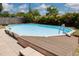 Above ground pool with small wood deck and ladder surrounded by mature landscaping at 2153 Catalina N Dr, Clearwater, FL 33763