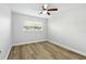 Cozy bedroom featuring wood-look floors, a ceiling fan, and bright light at 2286 Norwegian Dr # 8, Clearwater, FL 33763