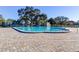 Large community pool with a surrounding brick deck and lounge chairs and umbrellas at 2286 Norwegian Dr # 8, Clearwater, FL 33763