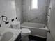 Bathroom featuring a tub, a toilet, a sink, and black and grey accent walls at 23015 Mayfair Rd, Land O Lakes, FL 34639
