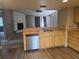 Cozy kitchen with wood cabinets, stainless steel dishwasher, and view into the living room with a fireplace at 23015 Mayfair Rd, Land O Lakes, FL 34639