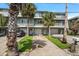 Exterior of condo building featuring garage parking, pedestrian walkways, and well-maintained landscaping at 2511 Bay Blvd # B, Indian Rocks Beach, FL 33785