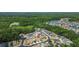 Aerial view showcases the property's location within a lush, green neighborhood with trees and a nearby community lake at 25830 Crippen Dr, Land O Lakes, FL 34639