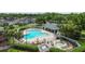 Aerial view of a community pool with lounge chairs and a hot tub surrounded by lush landscaping at 25830 Crippen Dr, Land O Lakes, FL 34639
