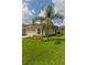 Charming single-story home boasts a well-manicured lawn and tropical palm tree at 25830 Crippen Dr, Land O Lakes, FL 34639