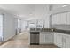 Open kitchen area with stainless steel dishwasher and granite countertops, flowing to a carpeted living space at 25830 Crippen Dr, Land O Lakes, FL 34639