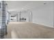 Spacious living room with light gray walls, plush carpeting, and sliding glass doors to the outdoor patio at 25830 Crippen Dr, Land O Lakes, FL 34639