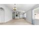Open living room with modern lighting fixtures and neutral carpeting at 25830 Crippen Dr, Land O Lakes, FL 34639